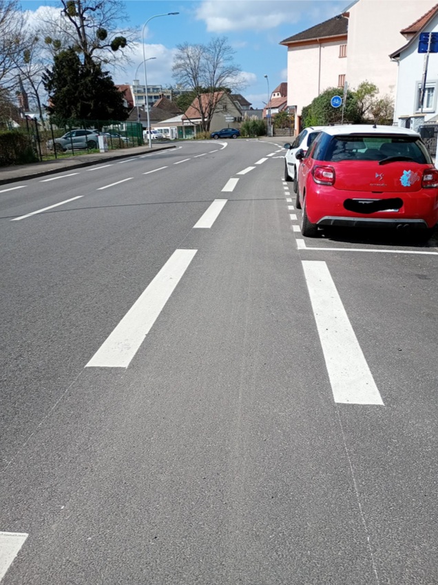 Rue Mélanie : section Ouest, une bande cyclable dangereuse qui ne permet pas d’éviter une ouverture de portière.